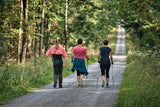 Three women enjoying a nature trail in secondhand women's activewear from our online thrift store